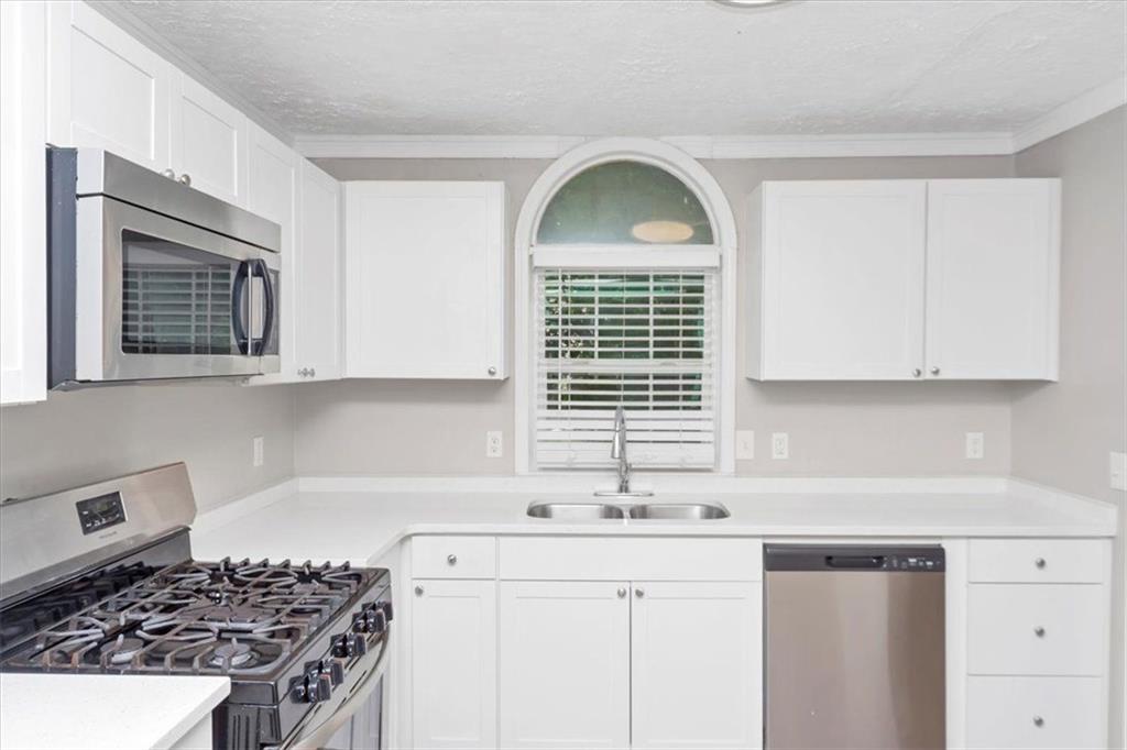 710 Country Manor Way Alpharetta, GA 30022 - Photo 8 of 33 a kitchen with stainless steel appliances a sink stove and cabinets