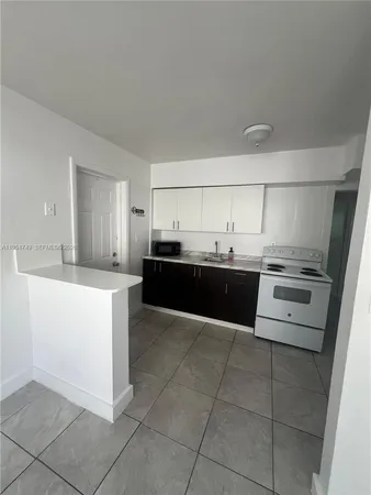 a kitchen with a sink window and white cabinets