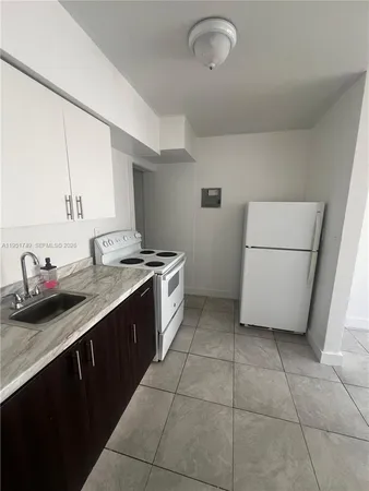 a kitchen with a sink a stove and a refrigerator
