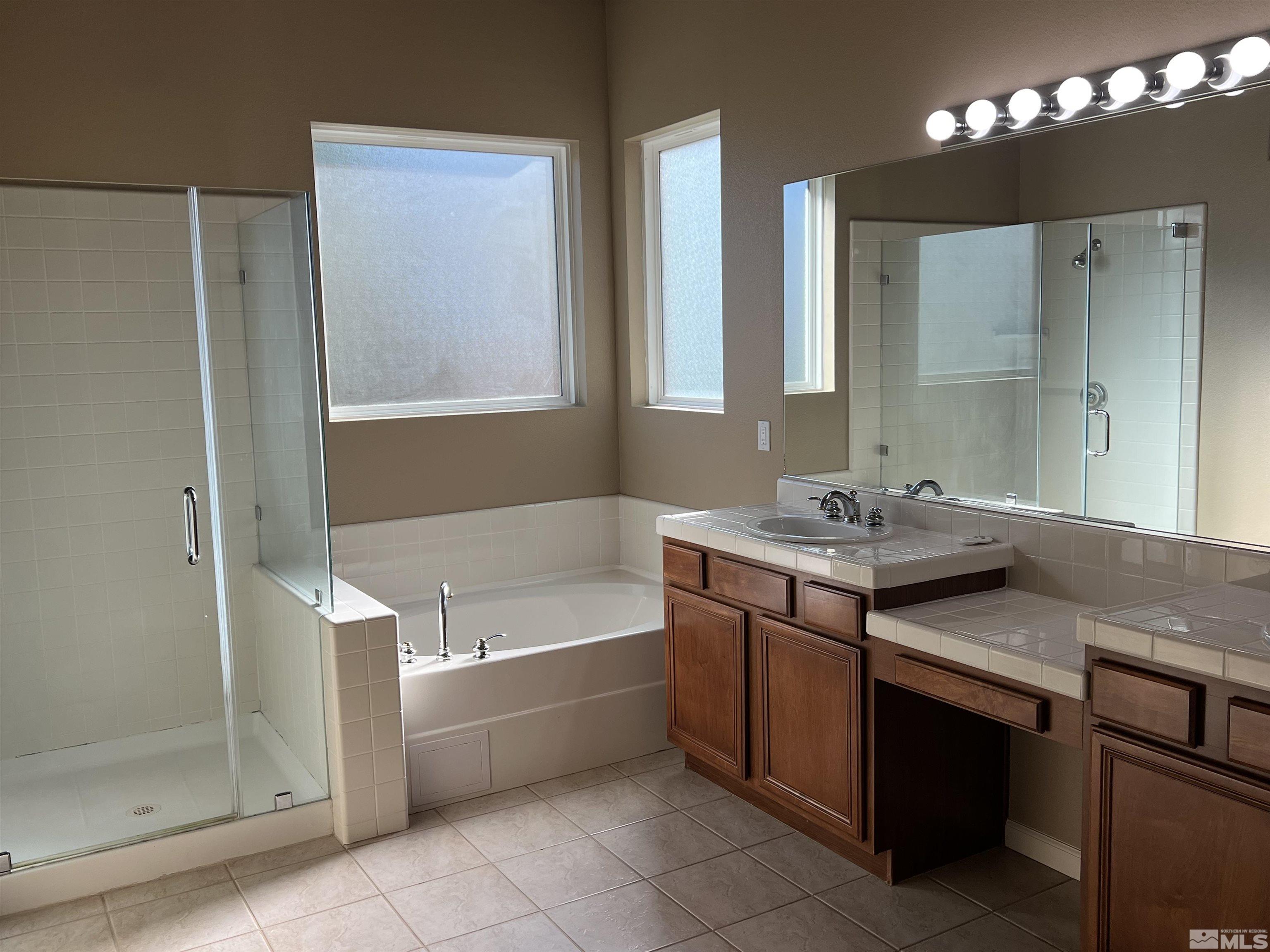 10600 Silver Cliff Way Reno, NV 89521 - Photo 11 of 24 a bathroom with a tub a sink and mirror