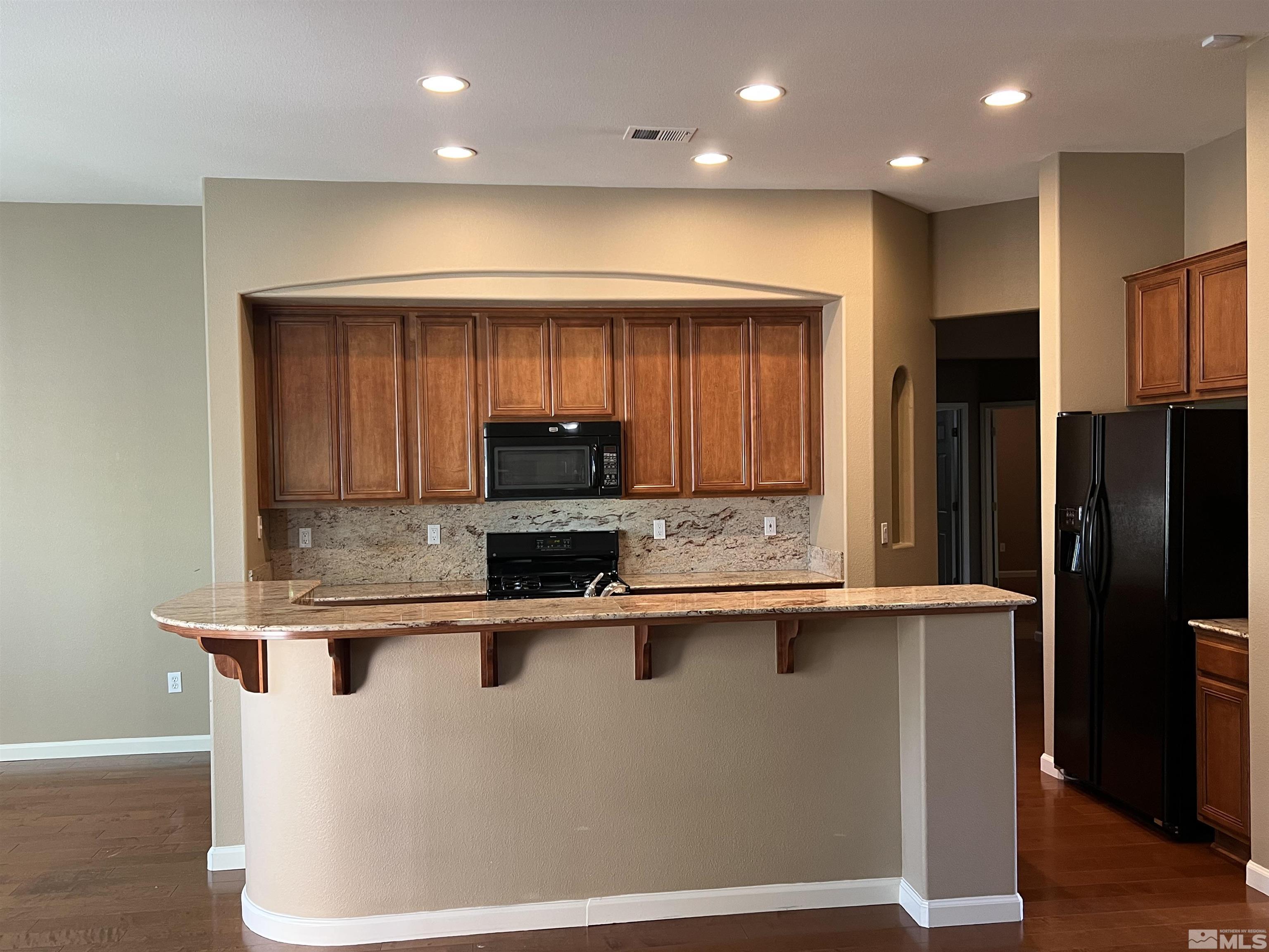 10600 Silver Cliff Way Reno, NV 89521 - Photo 6 of 24 a kitchen with stainless steel appliances granite countertop a sink a stove and a refrigerator