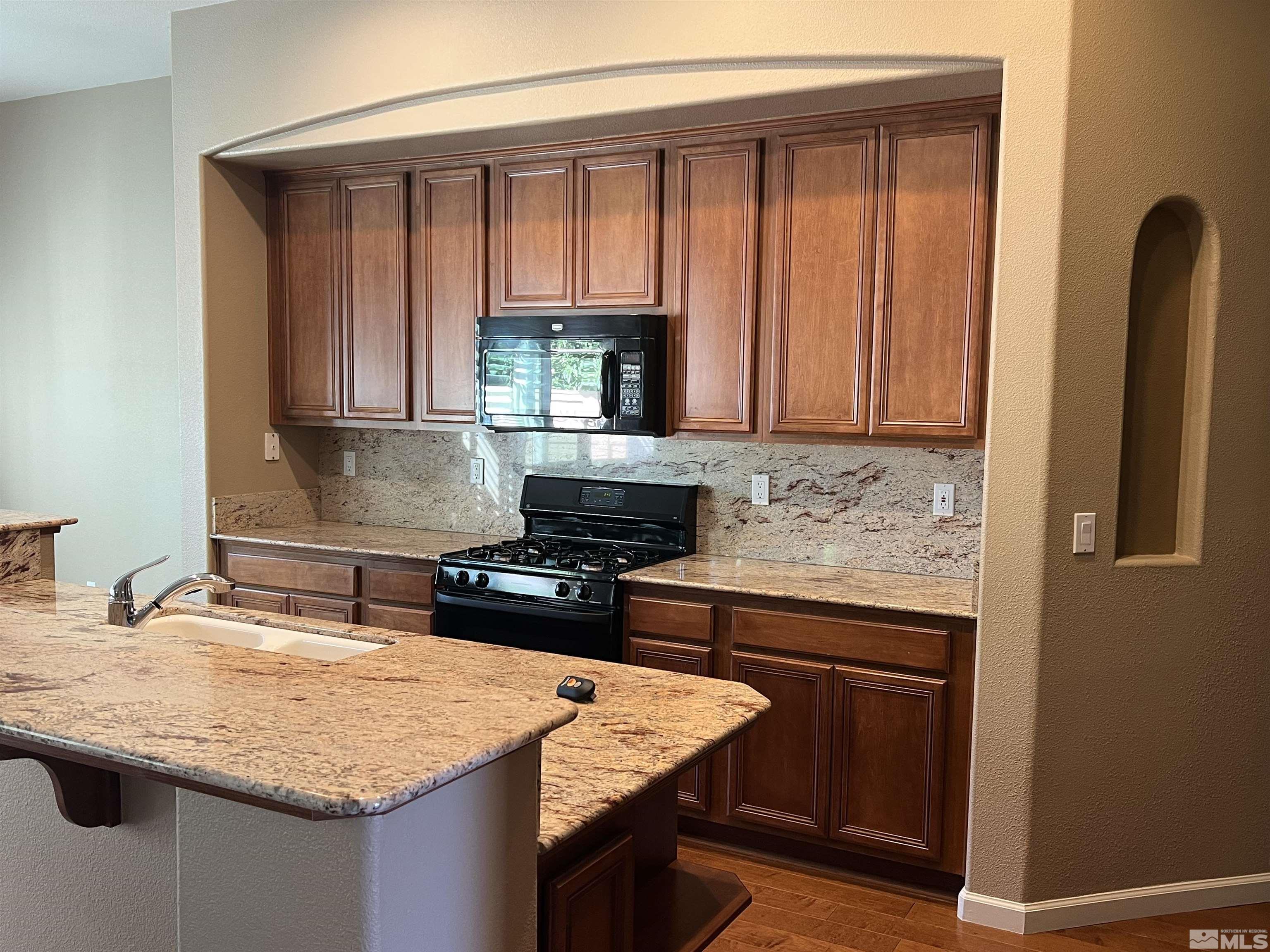 10600 Silver Cliff Way Reno, NV 89521 - Photo 7 of 24 a kitchen with granite countertop a sink stove and cabinets