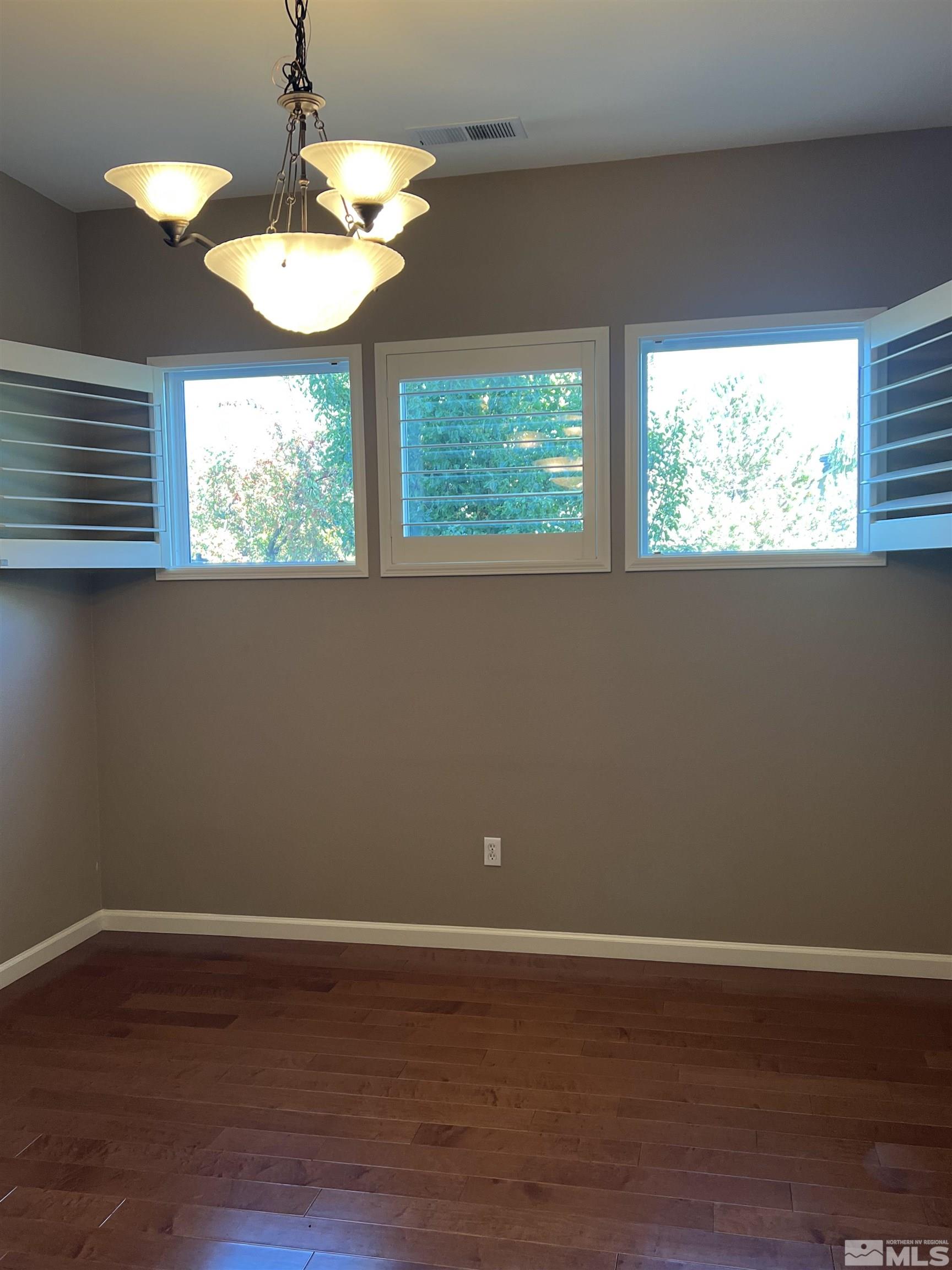 10600 Silver Cliff Way Reno, NV 89521 - Photo 9 of 24 an empty room with wooden floor and windows