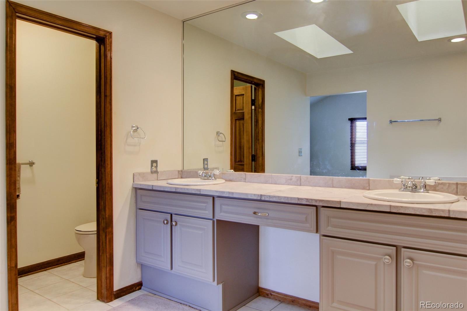 8096 Sweet Water Road Lone Tree, CO 80124 - Photo 16 of 25 a bathroom with a double vanity sink and a mirror