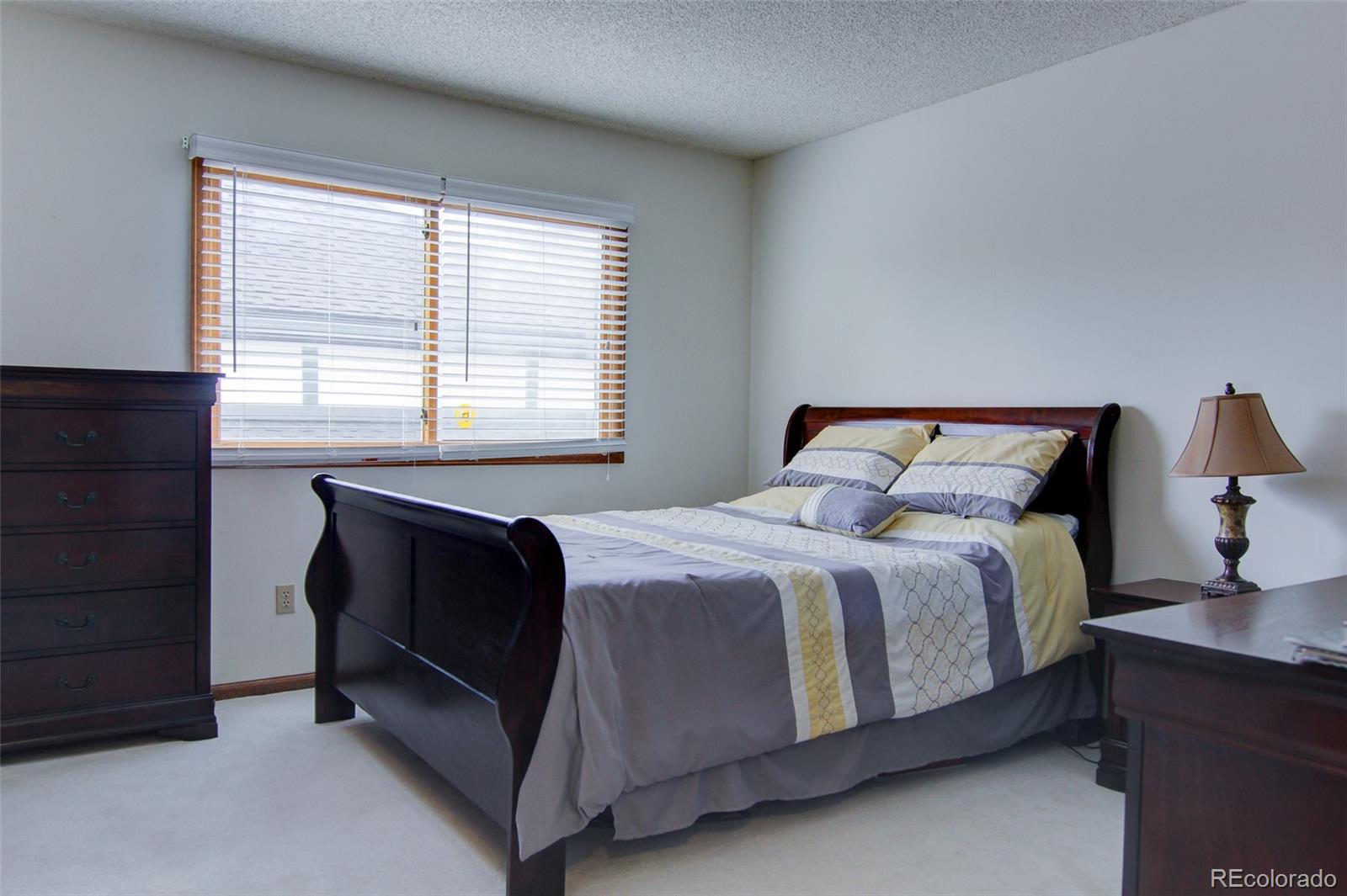 8096 Sweet Water Road Lone Tree, CO 80124 - Photo 18 of 25 a bedroom with a bed and a window