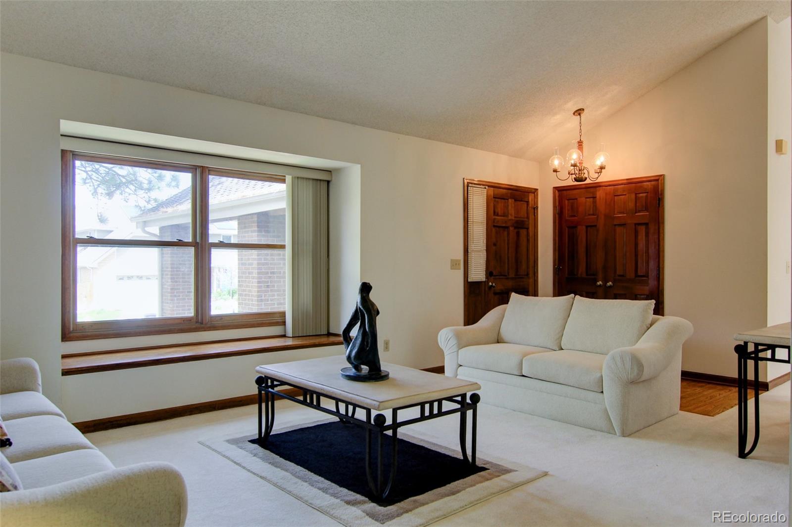 8096 Sweet Water Road Lone Tree, CO 80124 - Photo 2 of 25 a living room with furniture and a chandelier