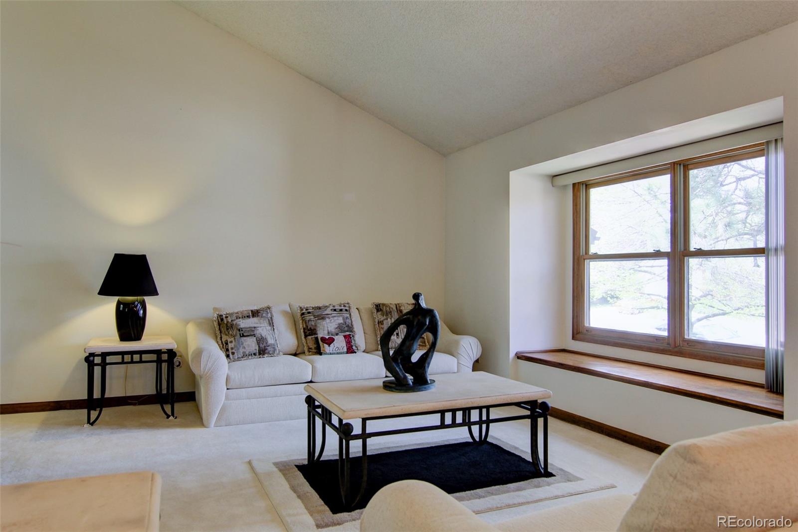 8096 Sweet Water Road Lone Tree, CO 80124 - Photo 3 of 25 a living room with furniture and a lamp