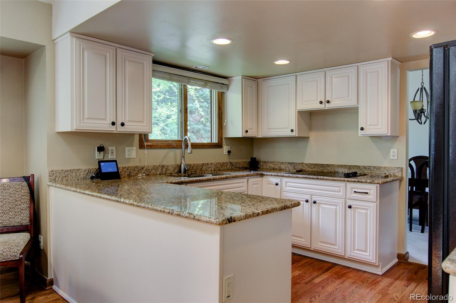 8096 Sweet Water Road Lone Tree, CO 80124 - Photo 5 of 25 a kitchen with stainless steel appliances granite countertop a stove a sink and white cabinets