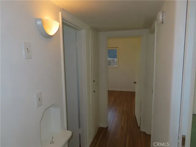 a view of a room with a hanging light and ceiling fan