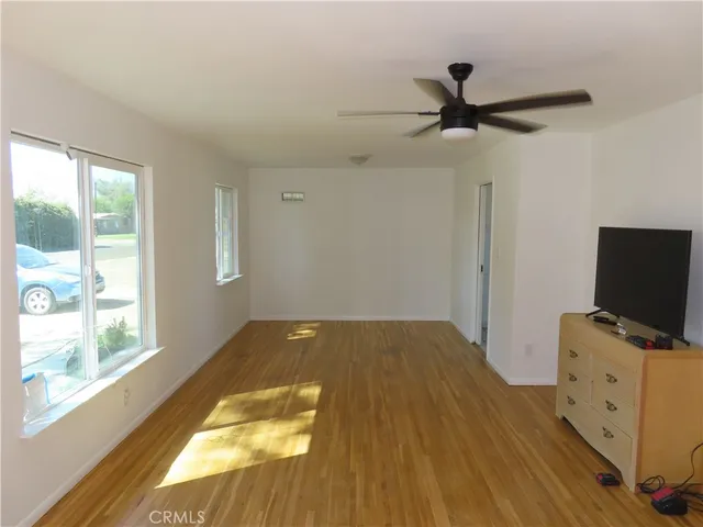 a bedroom with a bed and a flat tv screen on the dresser