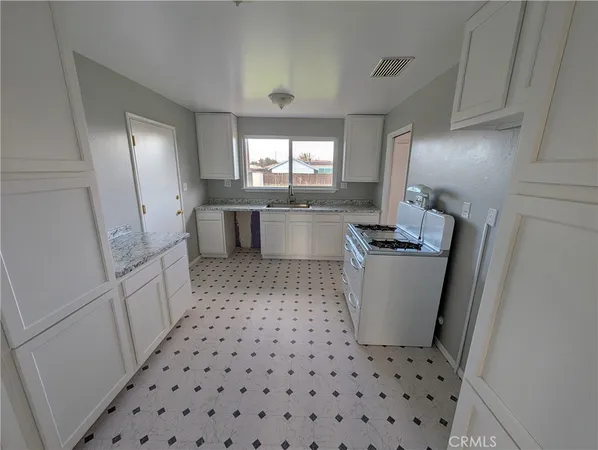 a kitchen with a stove a sink and a refrigerator
