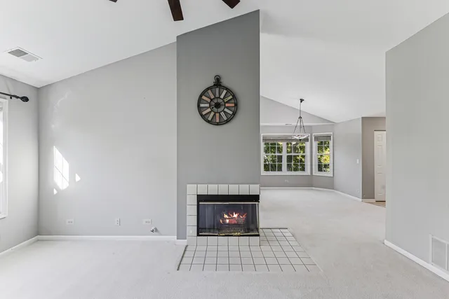 a view of an empty room with a window and fireplace