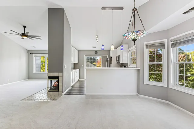 a view of a kitchen and a chandelier fan windows and kitchen view
