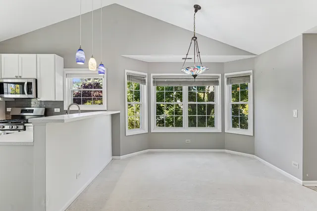 a open kitchen with white cabinets and window
