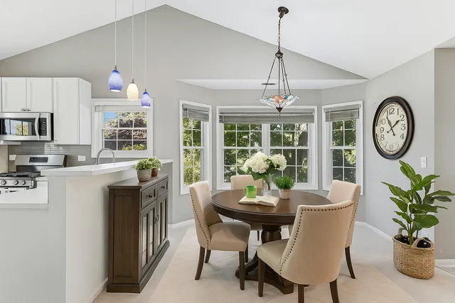 a dining room with furniture a large window and a clock