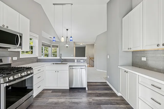 a kitchen with stainless steel appliances a white stove top oven and cabinets