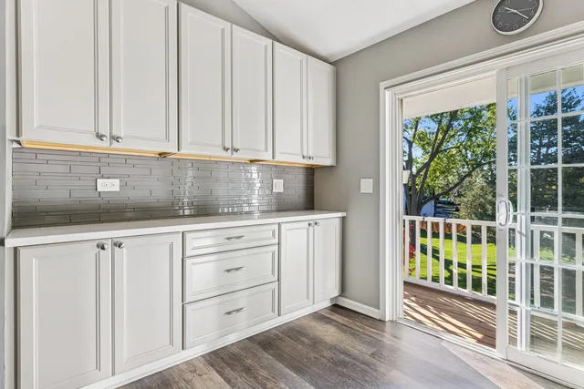 a kitchen with granite countertop white cabinets and window