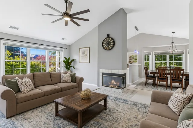 a living room with furniture ceiling fan and a fireplace