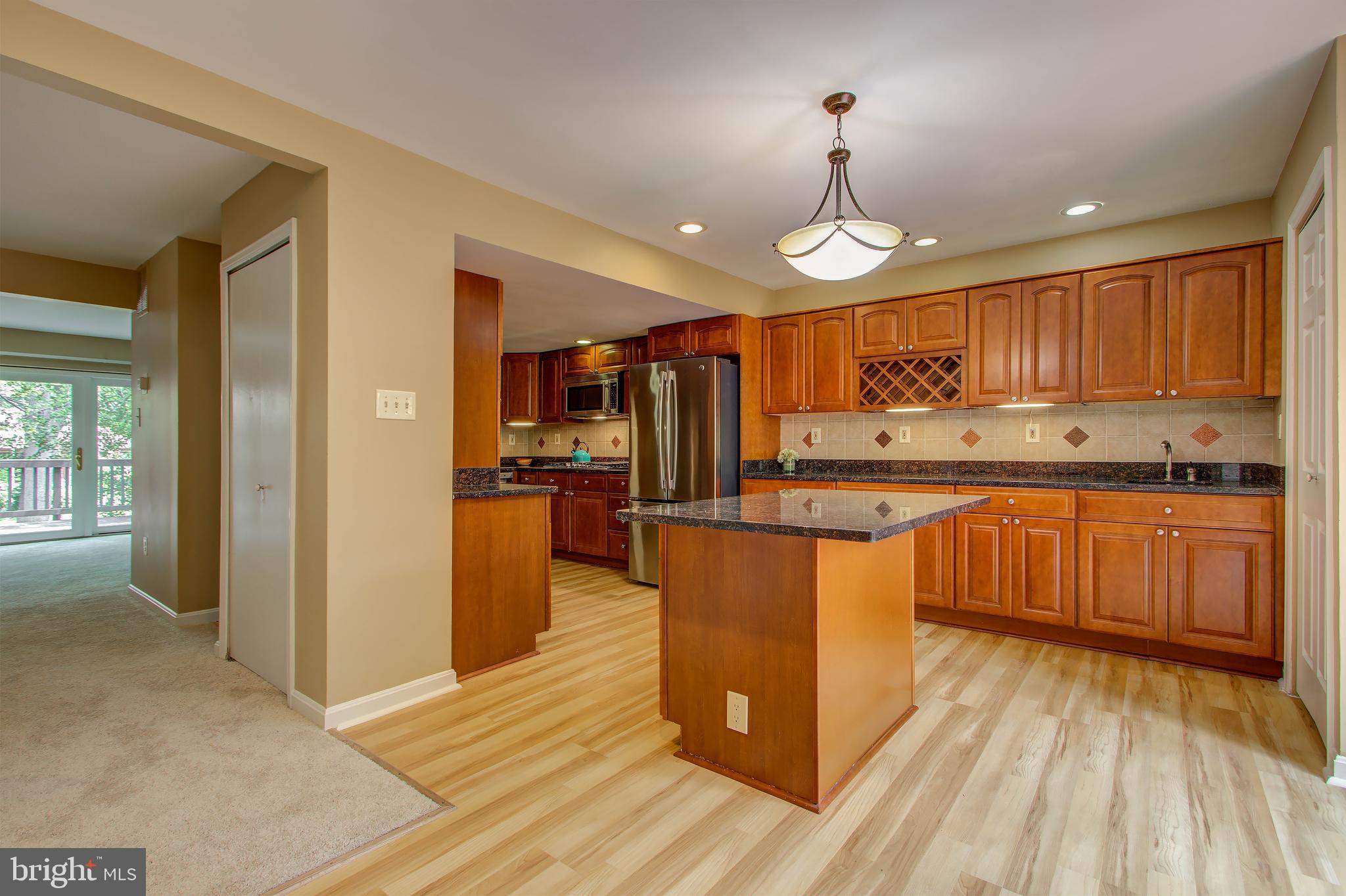 11024 Saffold Way Reston, VA 20190 - Photo 12 of 50 a large kitchen with stainless steel appliances granite countertop a stove refrigerator and cabinets