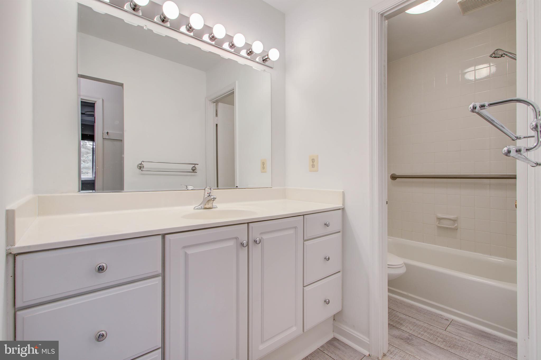 11024 Saffold Way Reston, VA 20190 - Photo 21 of 50 a bathroom with a double vanity sink a mirror and a bathtub