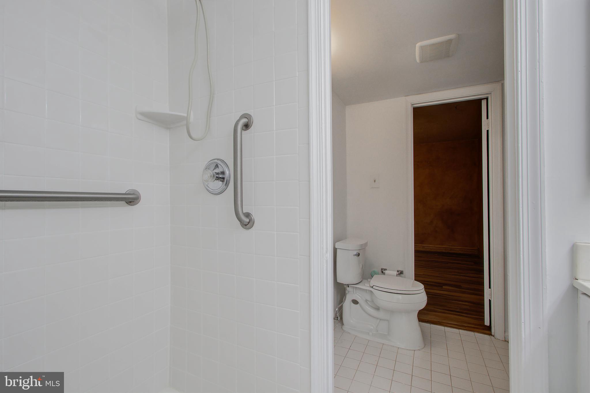 11024 Saffold Way Reston, VA 20190 - Photo 33 of 50 a bathroom with a granite countertop toilet and a shower