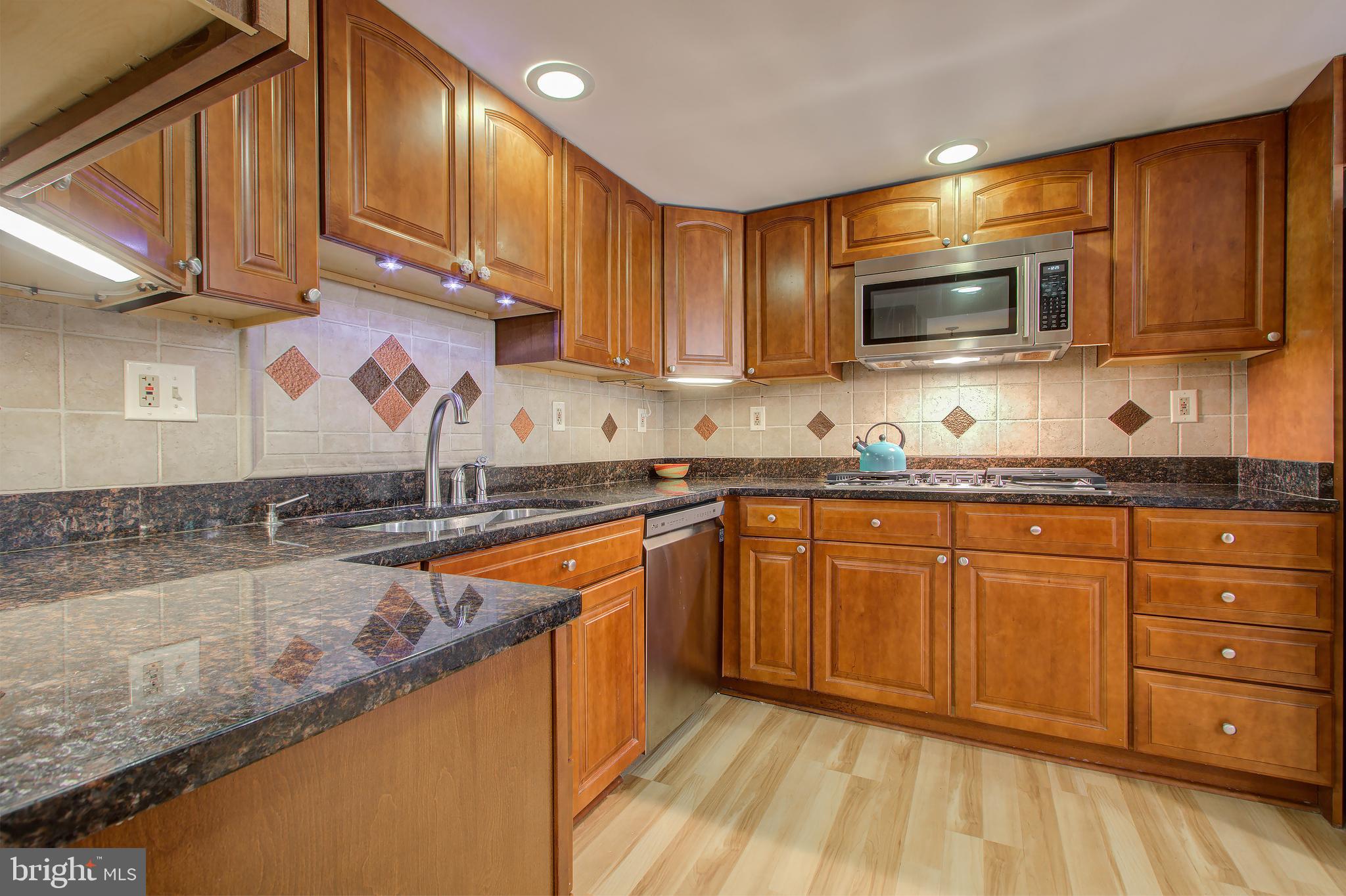 11024 Saffold Way Reston, VA 20190 - Photo 7 of 50 a kitchen with stainless steel appliances granite countertop wooden cabinets a sink and dishwasher