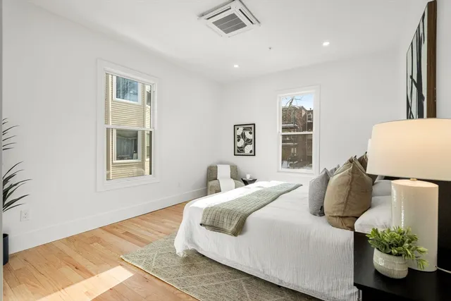 a bedroom with a bed and a potted plant