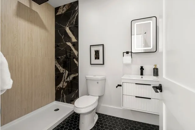 a bathroom with a toilet sink vanity and mirror