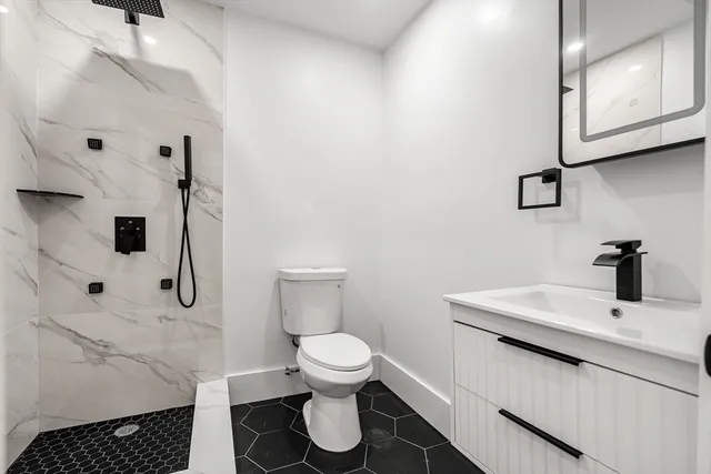 a bathroom with a toilet sink and mirror