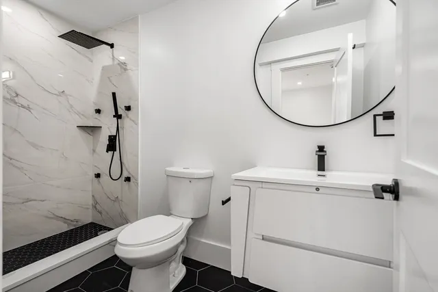 a bathroom with a sink toilet and a mirror