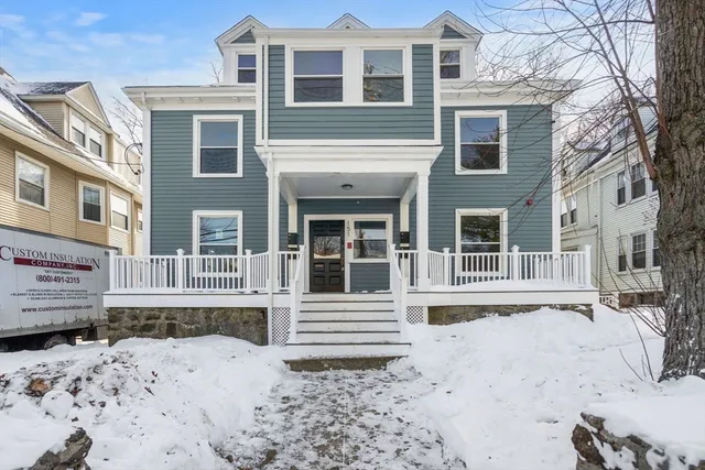 a front view of a house with a yard covered in snow