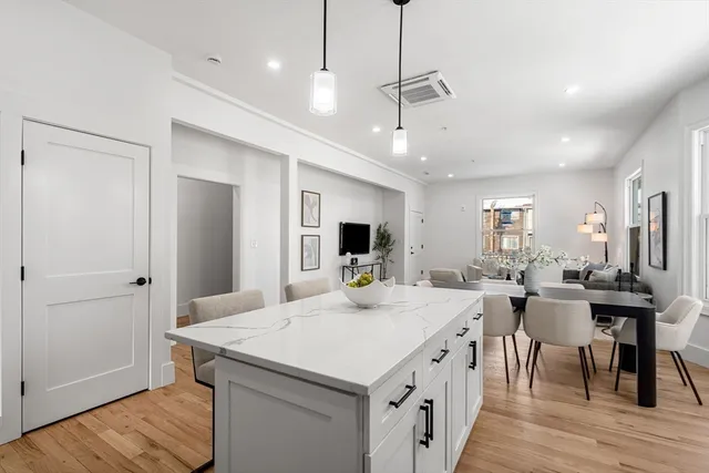 a view of a dining room and livingroom with furniture wooden floor a chandelier