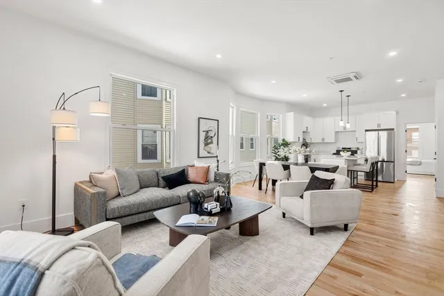 a living room with furniture and view of kitchen