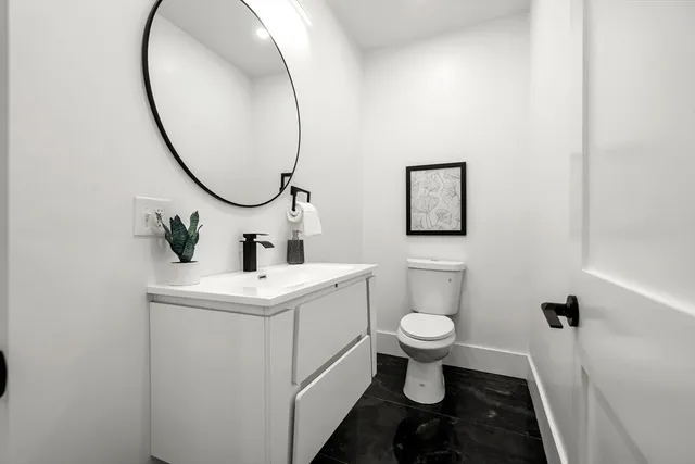 a bathroom with a sink toilet and a mirror