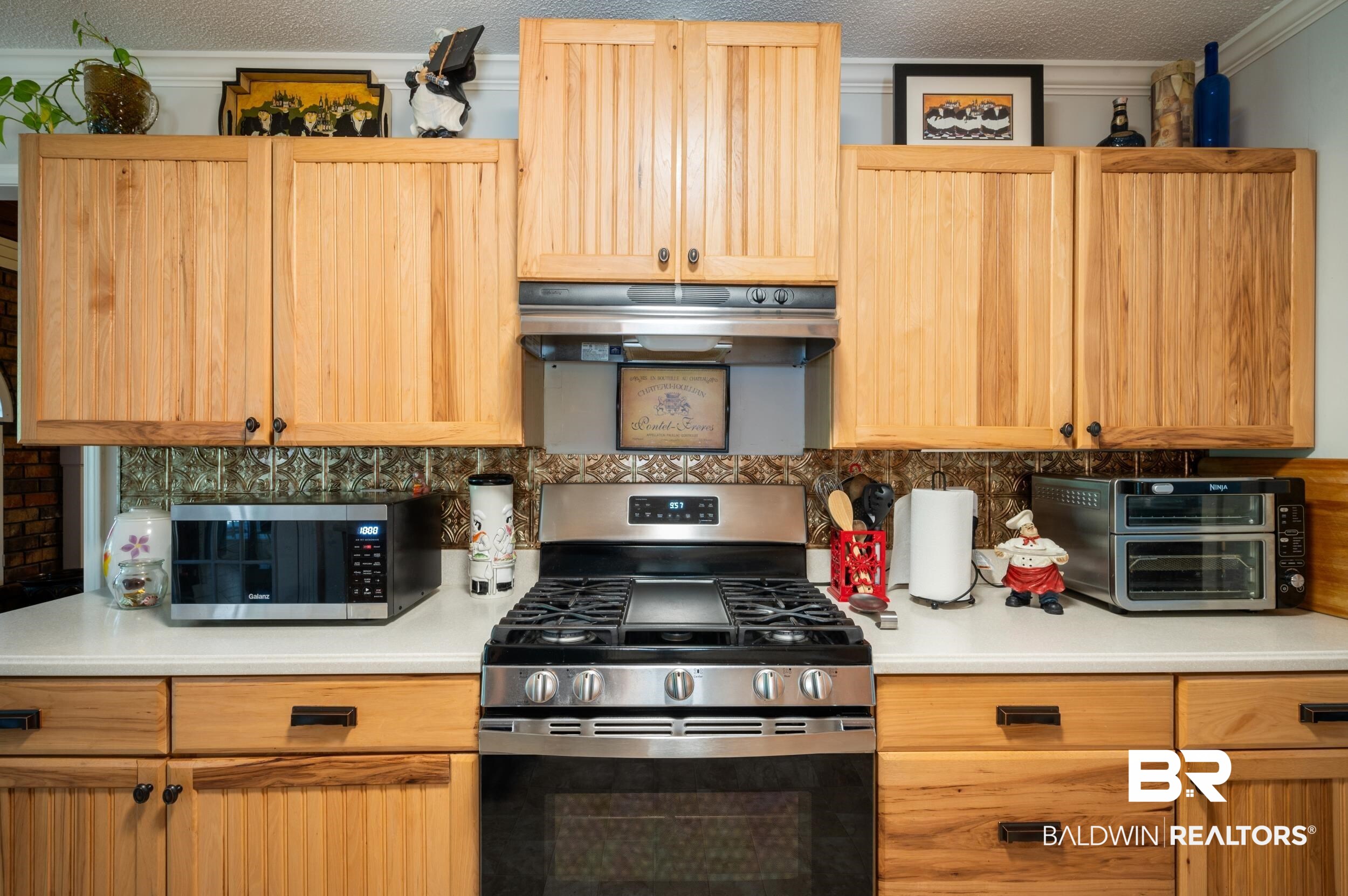 550 Norwood Road Monroeville, AL 36460 - Photo 16 of 46 Kitchen featuring stainless steel appliances, light countertops, light wood finish cabinets, backsplash, and a textured ceiling