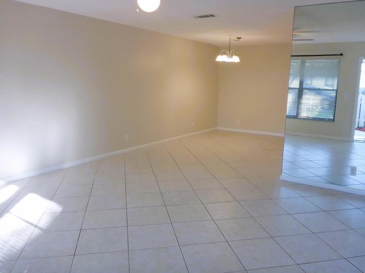431 Jupiter Lakes Boulevard, Unit 2109A Jupiter, FL 33458 - Photo 4 of 23 wooden floor in an empty room with a window