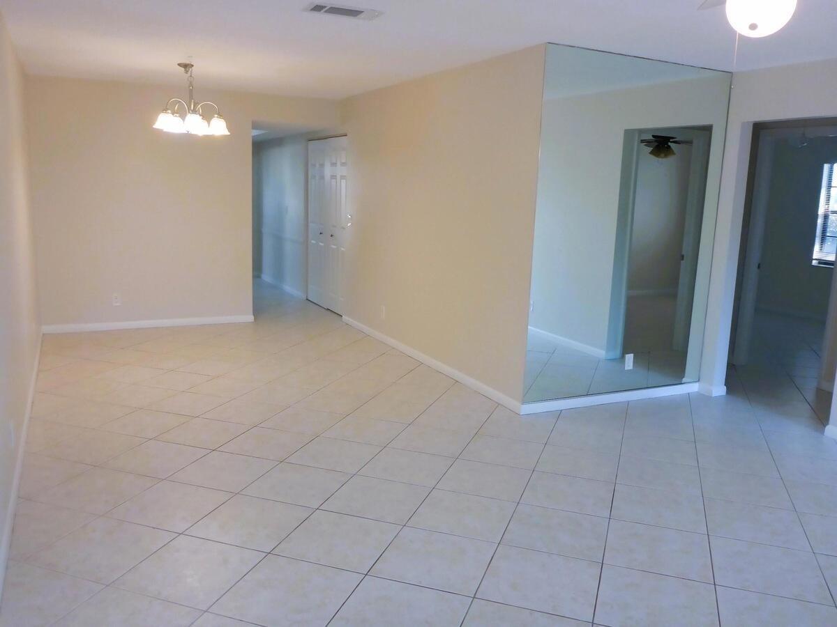 431 Jupiter Lakes Boulevard, Unit 2109A Jupiter, FL 33458 - Photo 5 of 23 an empty room with closet and a chandelier fan