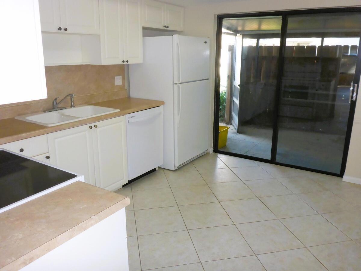 431 Jupiter Lakes Boulevard, Unit 2109A Jupiter, FL 33458 - Photo 9 of 23 a kitchen with a sink a refrigerator and cabinets