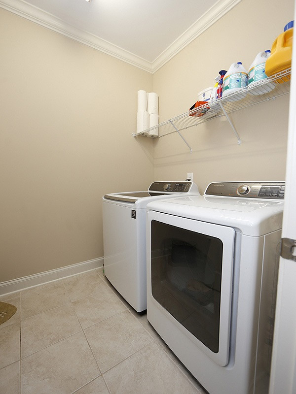1145 Chapanoke Road Raleigh, NC 27603 - Photo 13 of 25 The laundry room with tile floor and shelf for storage is located near the back garage door-very convenient! Laundry Room