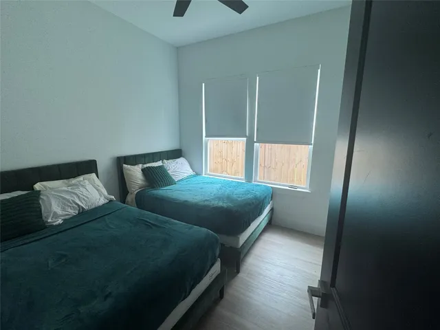 a bedroom with two beds and a large window