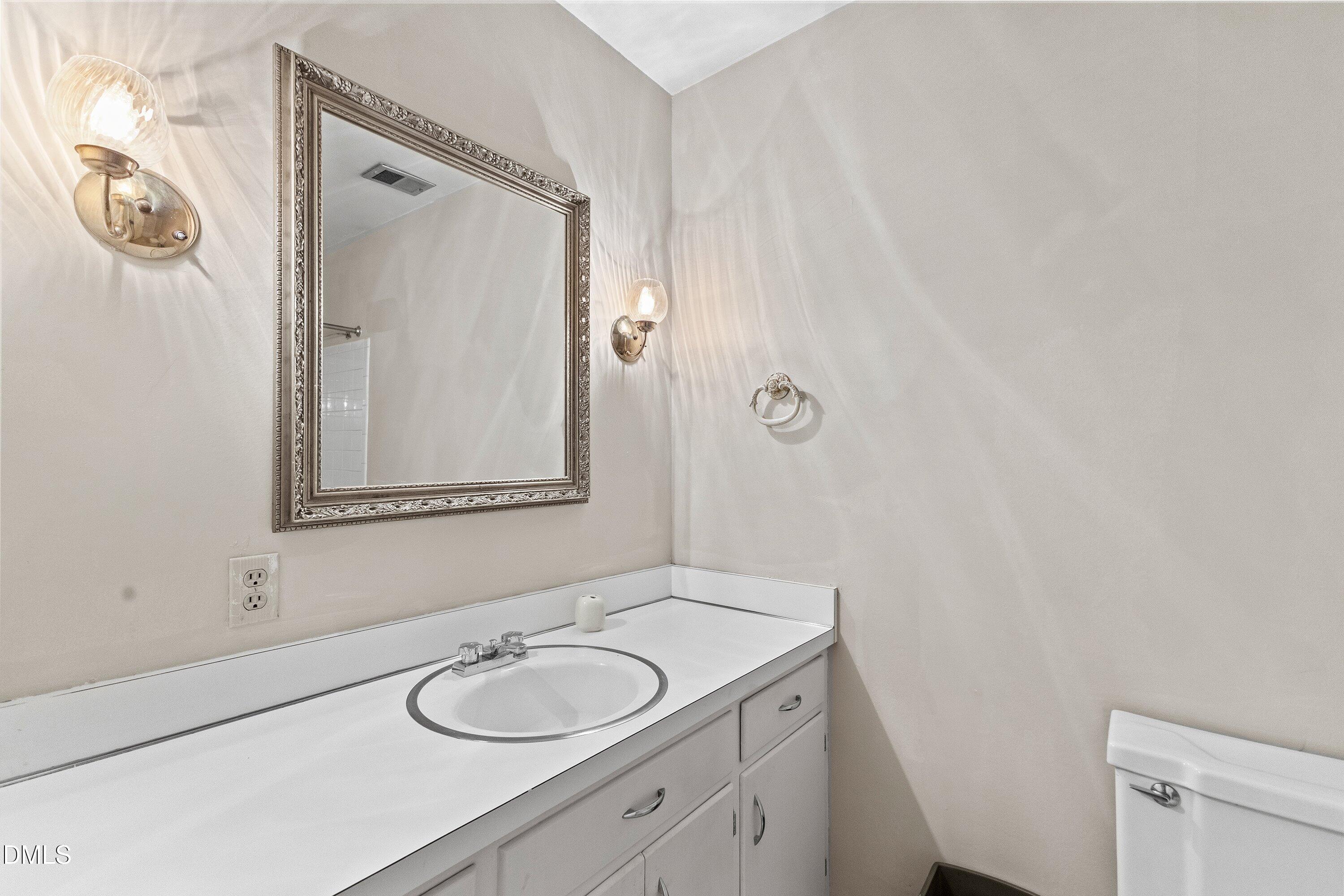 3605 Brentwood Road Raleigh, NC 27604 - Photo 22 of 42 a bathroom with a granite countertop sink and a mirror