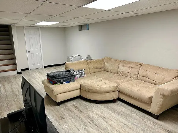 a living room with furniture and a wooden floor