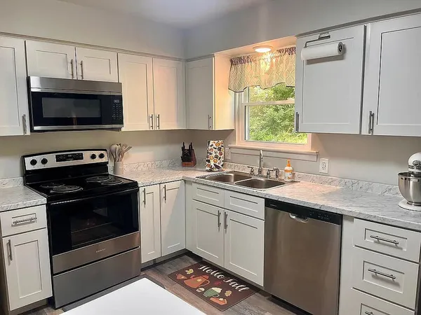 a kitchen with stainless steel appliances granite countertop a sink a stove a microwave and cabinets