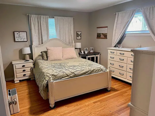 a bedroom with a bed and a tv on the dresser