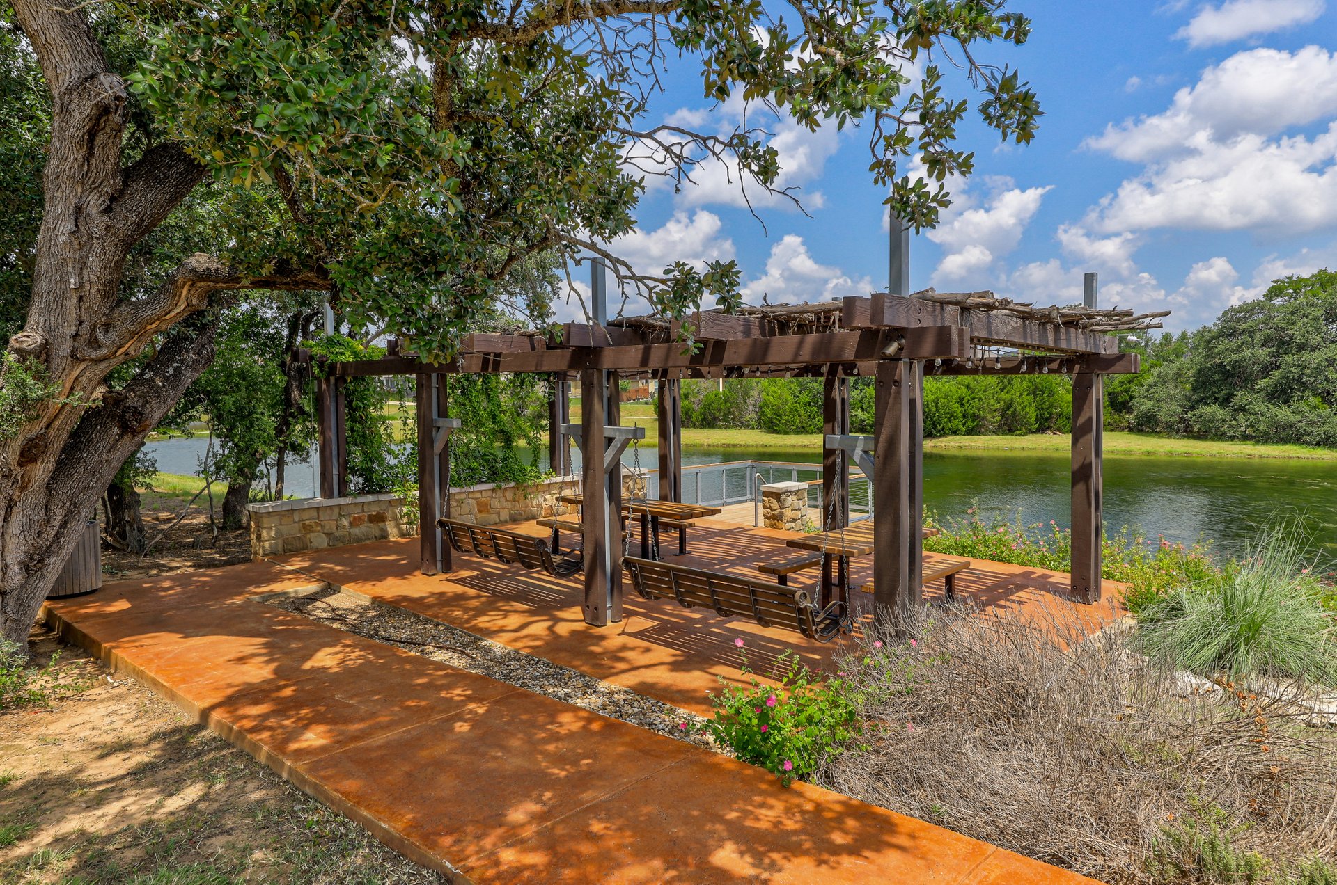 173 Santa Maria Street Georgetown, TX 78628 - Photo 38 of 39 Outdoor pergola structure featuring built-in wooden bench seating and a stone wall