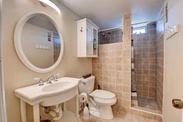 a bathroom with a sink toilet and mirror