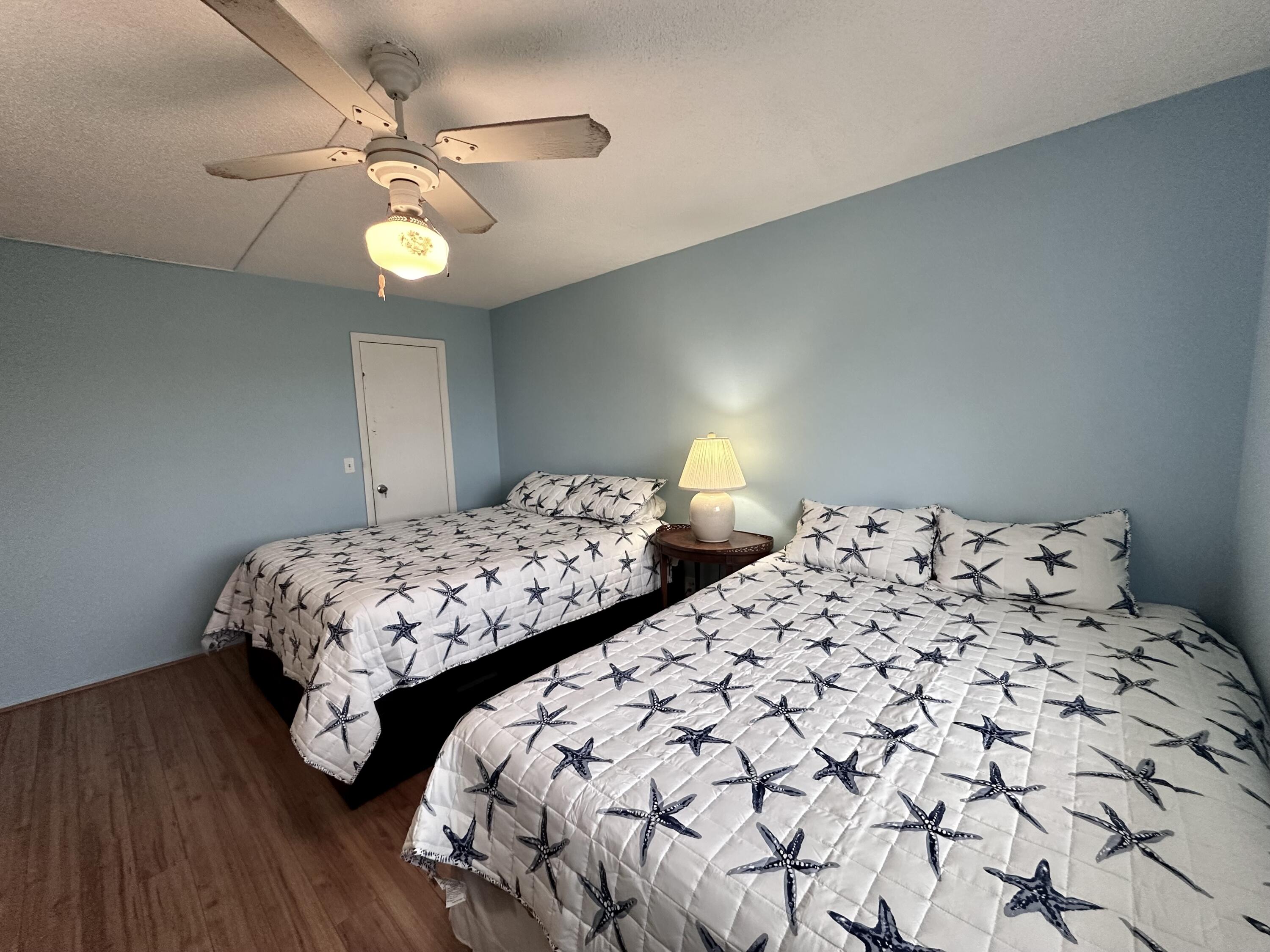2620 Northeast 1st Court, Unit 403 Boynton Beach, FL 33435 - Photo 17 of 42 a bedroom with two beds and a chandelier