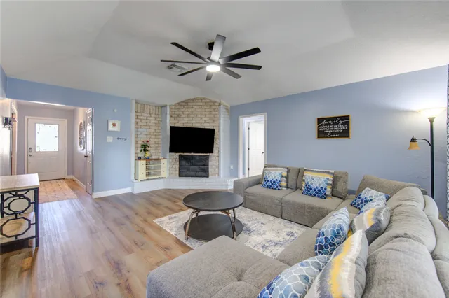 a living room with furniture a flat screen tv and a fireplace