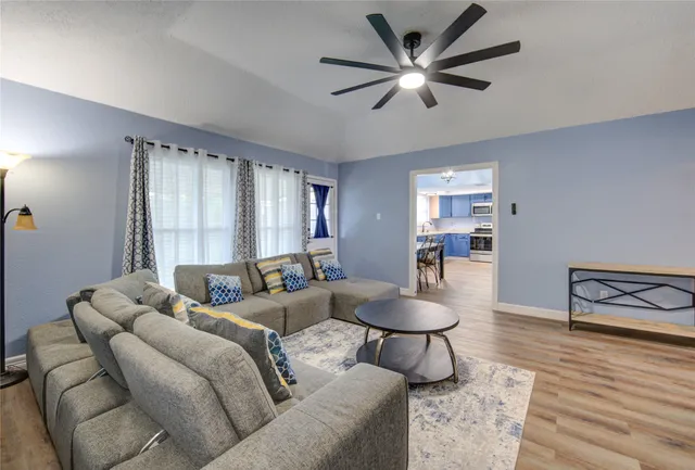 a living room with furniture and a wooden floor
