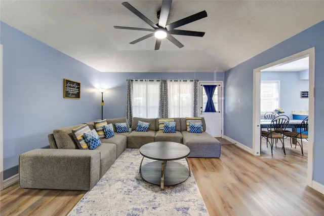 a living room with furniture and a wooden floor